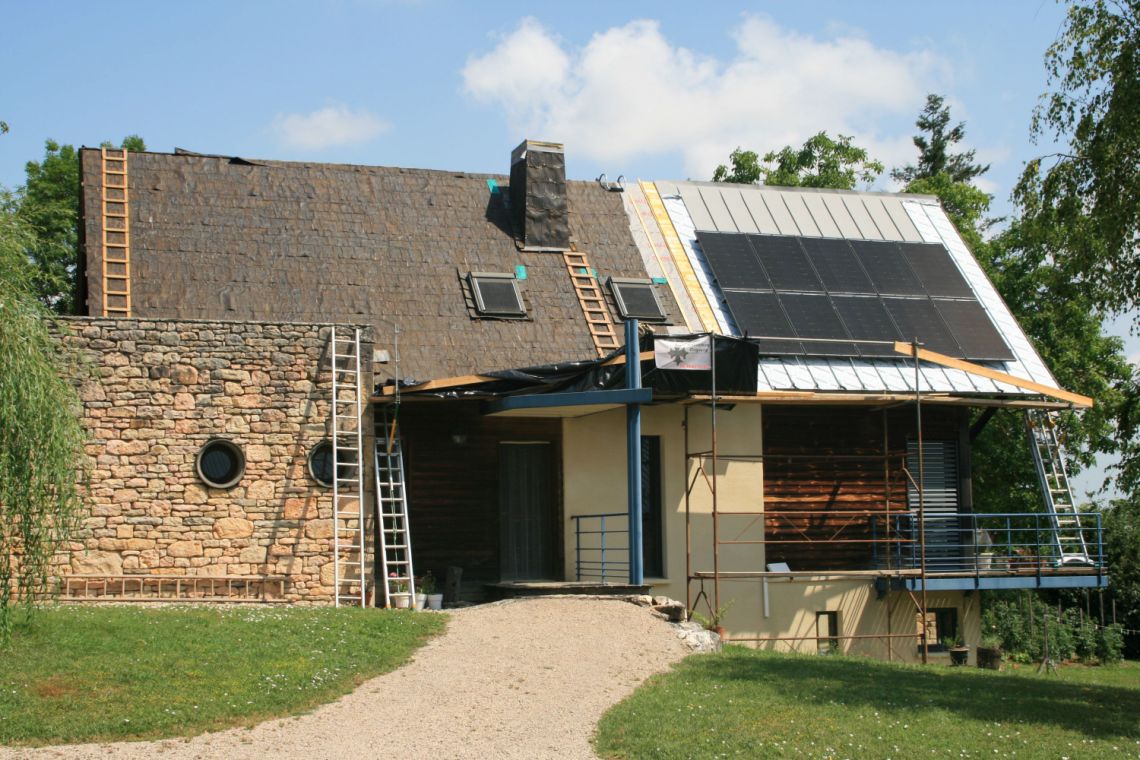 Installation PV avec vente de surplus sur la toiture d'une maison en zinc en rénovation.